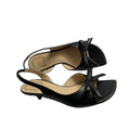 A pair of black leather Christian Dior slingback mule sandals with bow details, displayed on top of their white Dior shoebox.